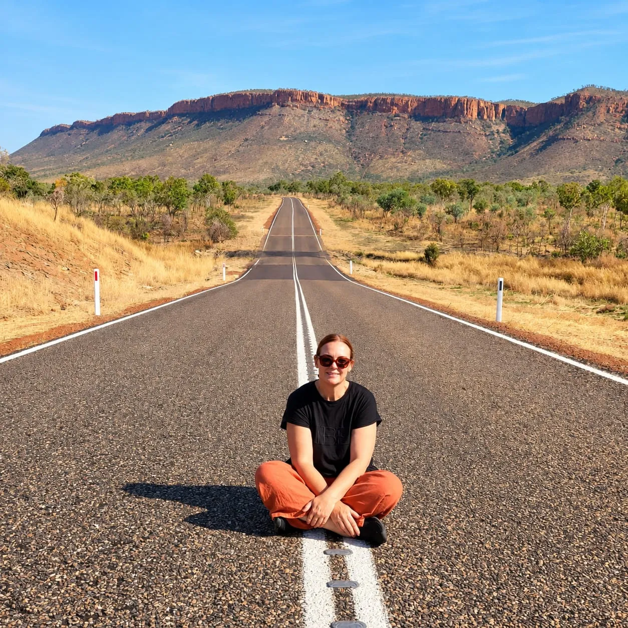 Sharon Joiner sitting on the Gibb River Road in front of the Cockburn Ranges, the Kimberley